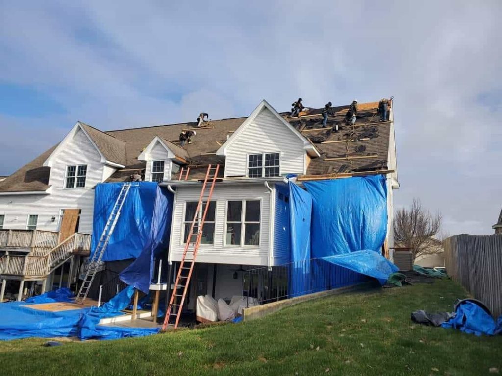 Roof contractors replace the roof on a suburban house.